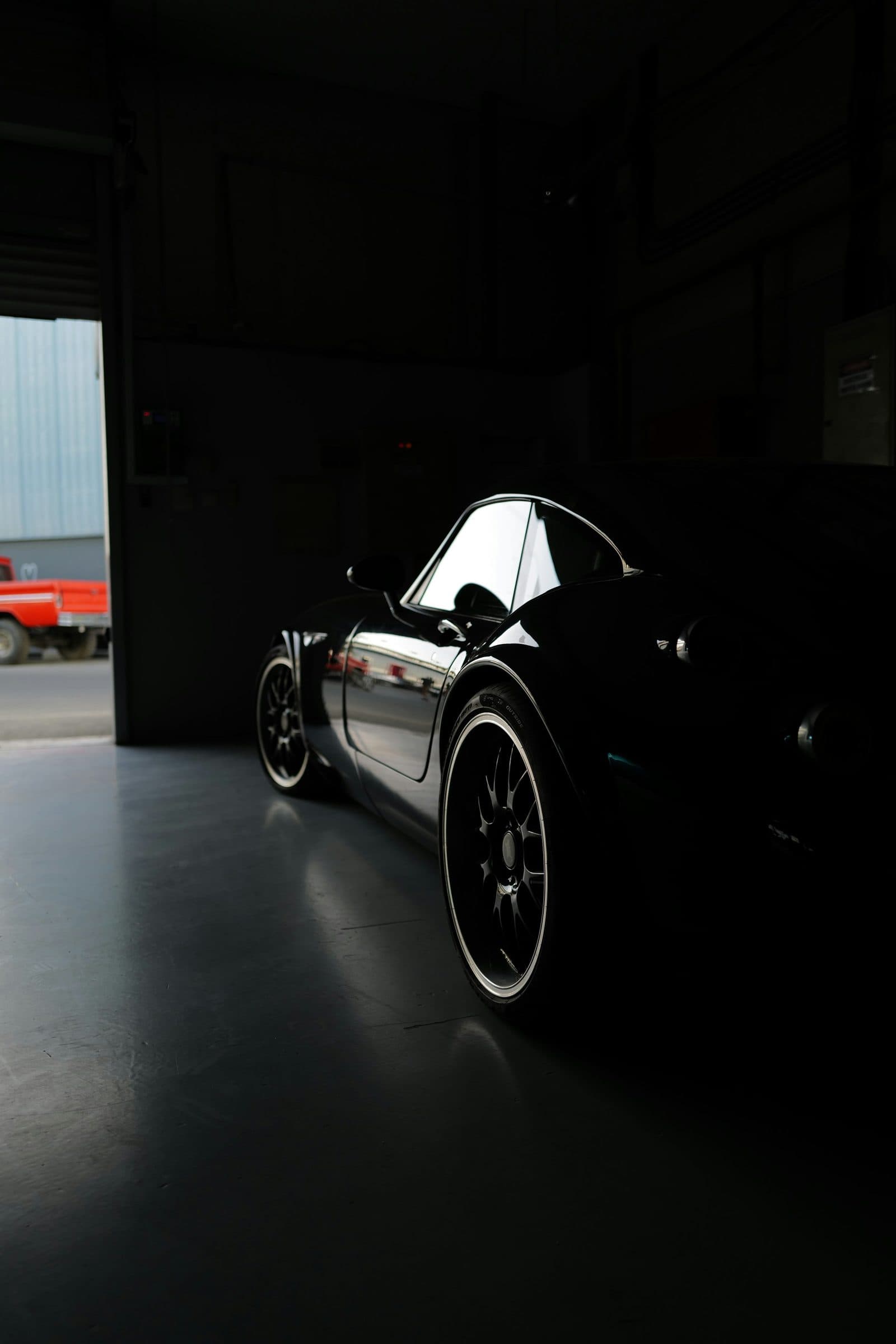 Porsche 911 noire à l’abri dans un garage sombre